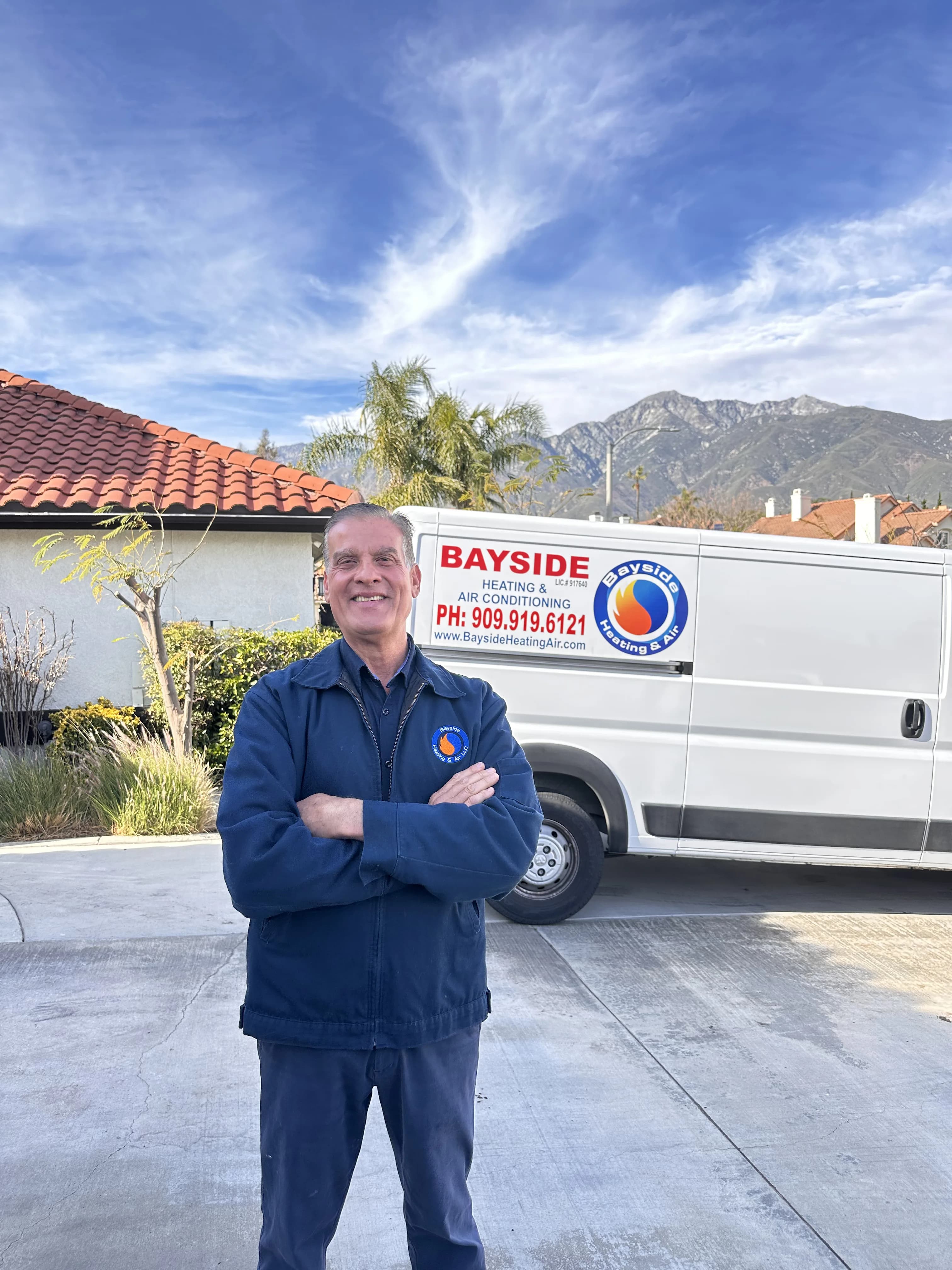 HVAC technician standing in front of service van